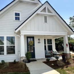 a house with a small front porch and a flower bed